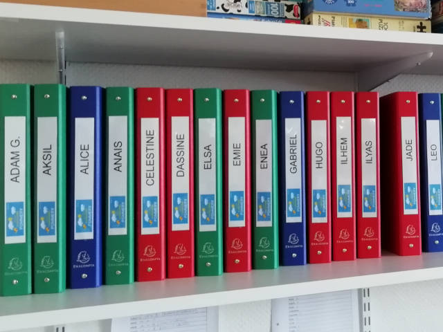 Des classeurs sur une étagère.